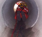 man get lowered into a sewer
